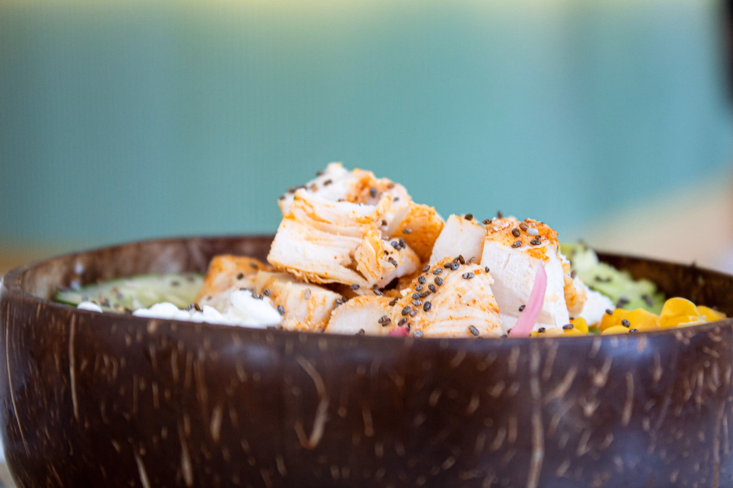 Bowl de coco con pollo, verduras y salsa